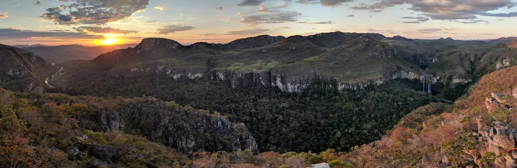 Vista do Mirante da Janela ao pôr do sol, com o vale encaixado entre paredões e a serra ao fundo
