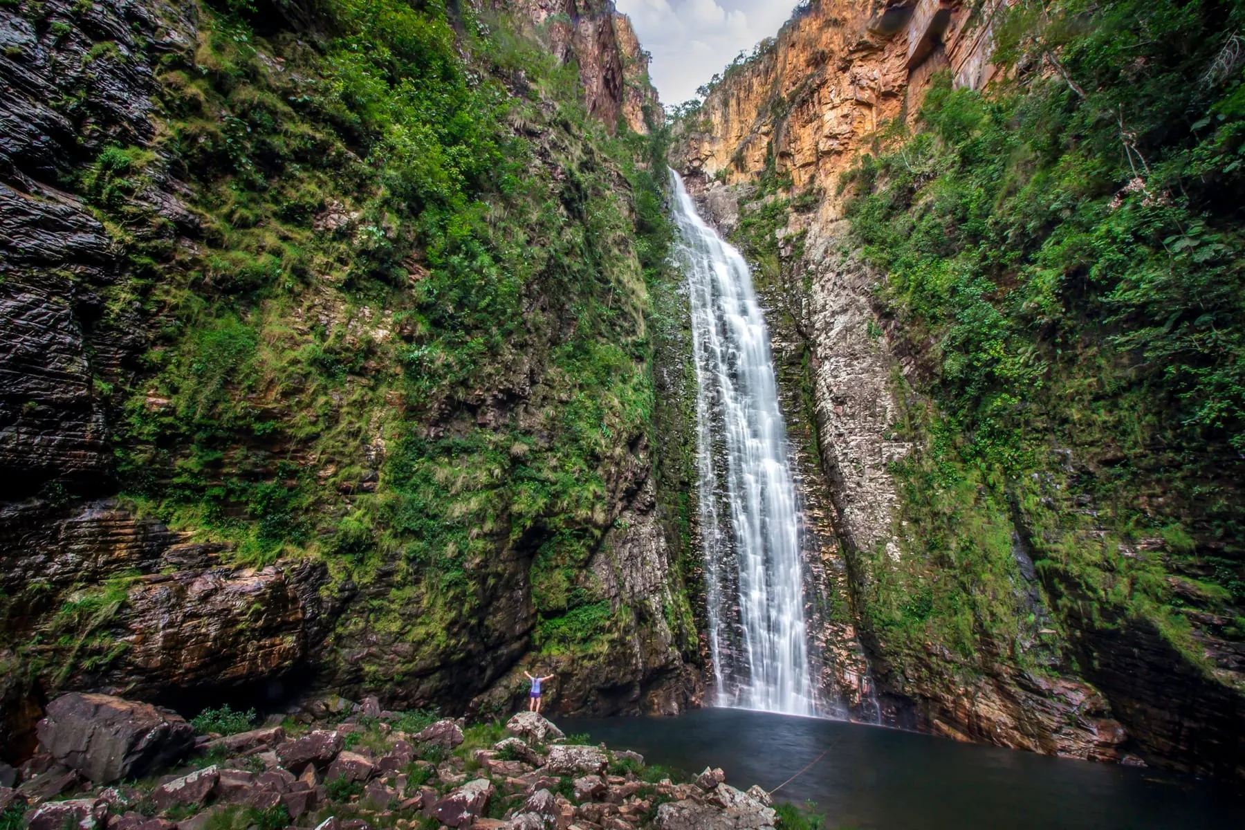 Cachoeira do Segredo: duas quedas altas e estreitas descendo um paredão coberto de vegetação