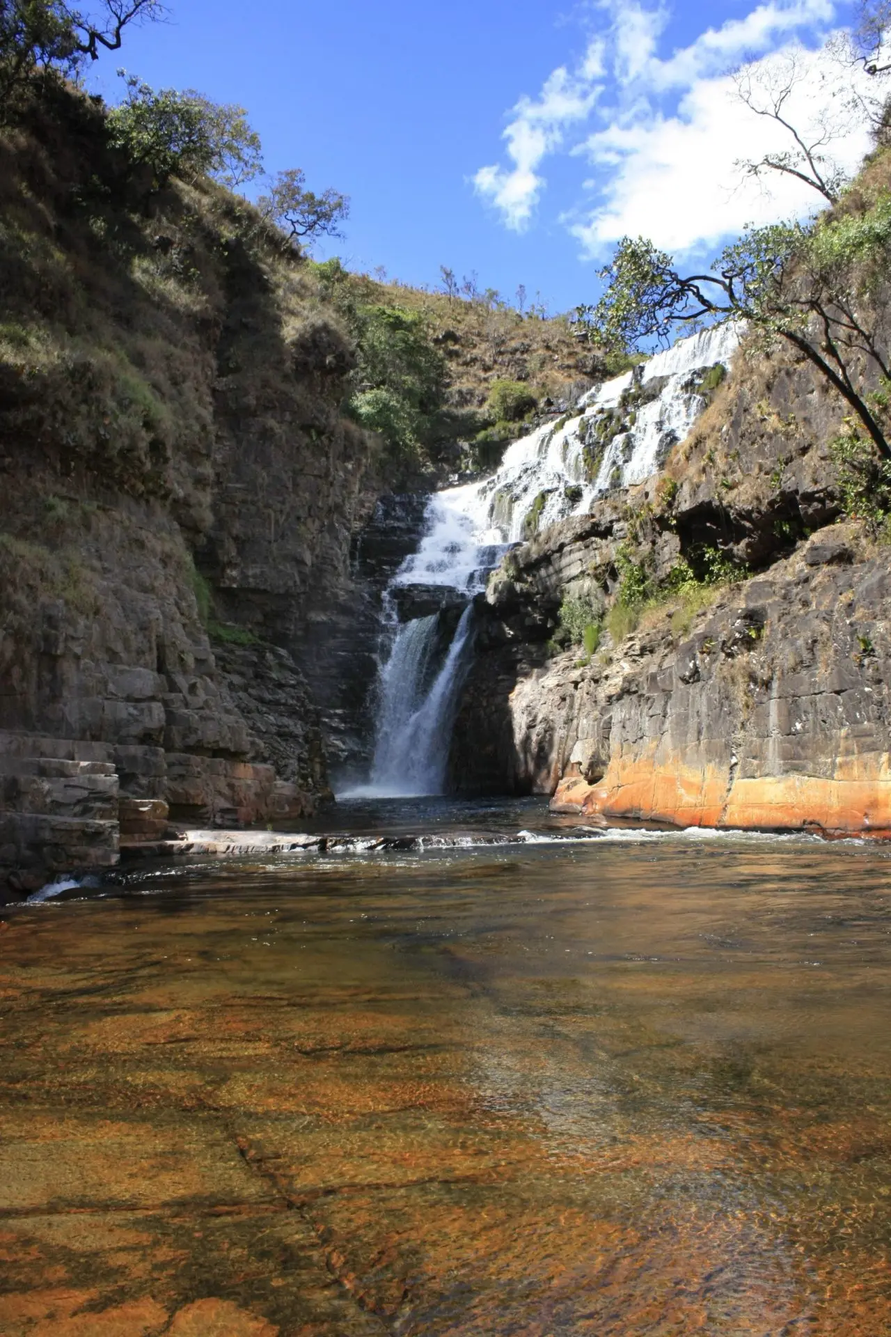 Cachoeira dos Macaquinhos com queda d'água entre rochas e poço de águas cristalinas na Chapada dos Veadeiros