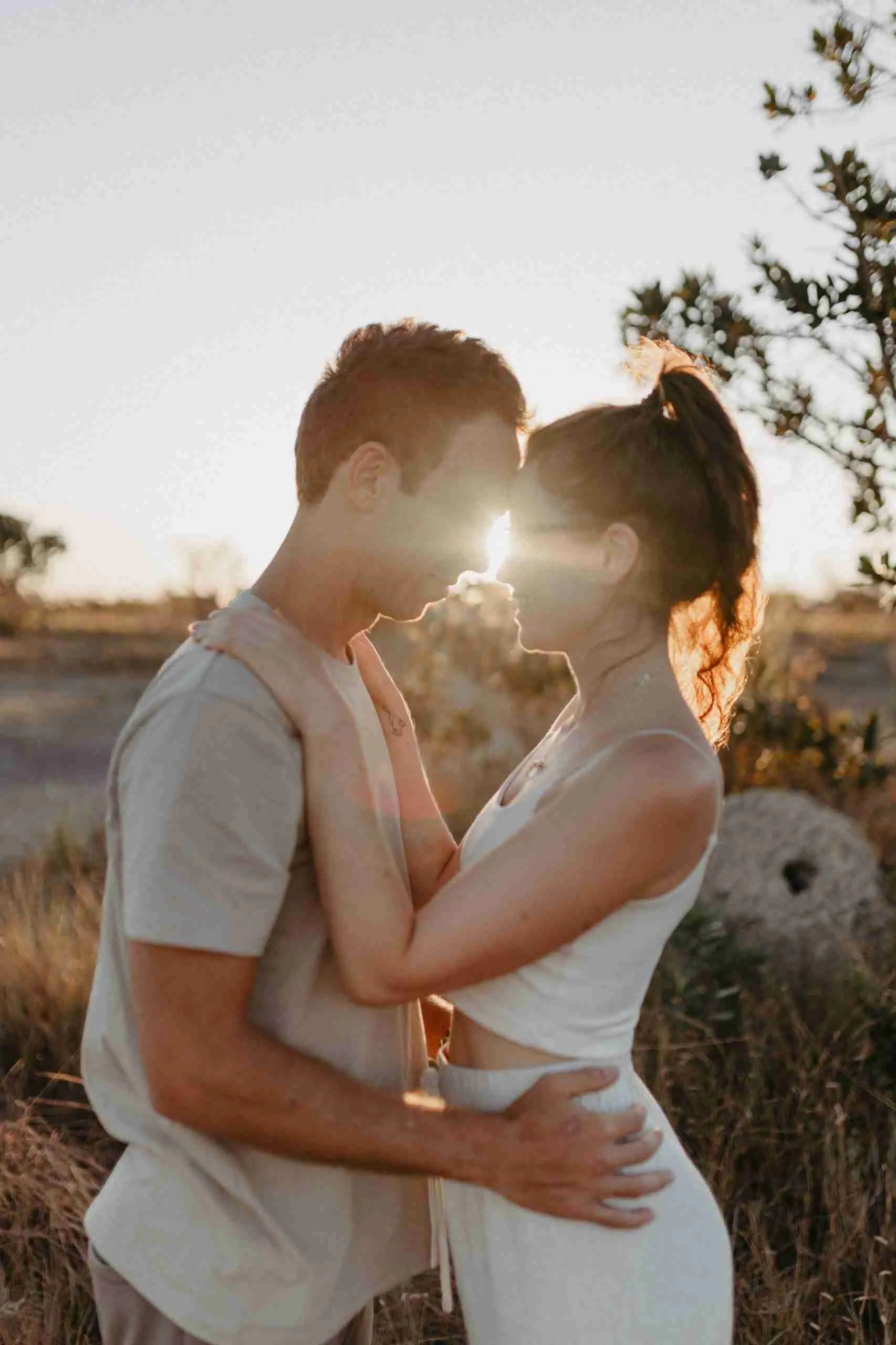 Casal em momento romântico com luz do pôr do sol entre os rostos no Cerrado do Paradise Ranch